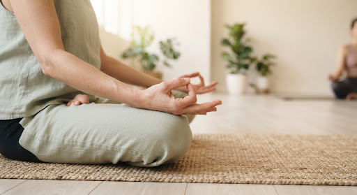 Hands resting on knees in a meditation pose during morning yoga